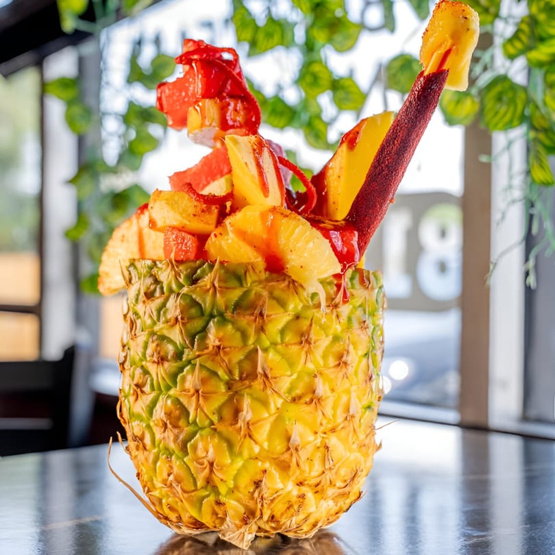 A pineapple filled with fresh fruit, chamoy, and chili powder, served at Mangonadas Mexican Kitchen.